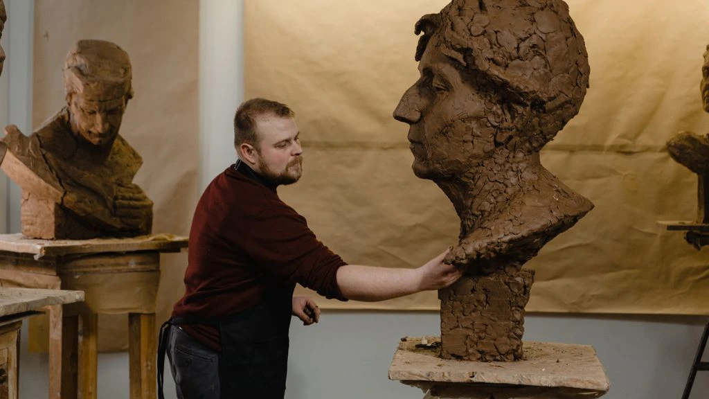 A hand-formed necktie sculpture resting on a wooden armature inside the Brooklyn atelier.