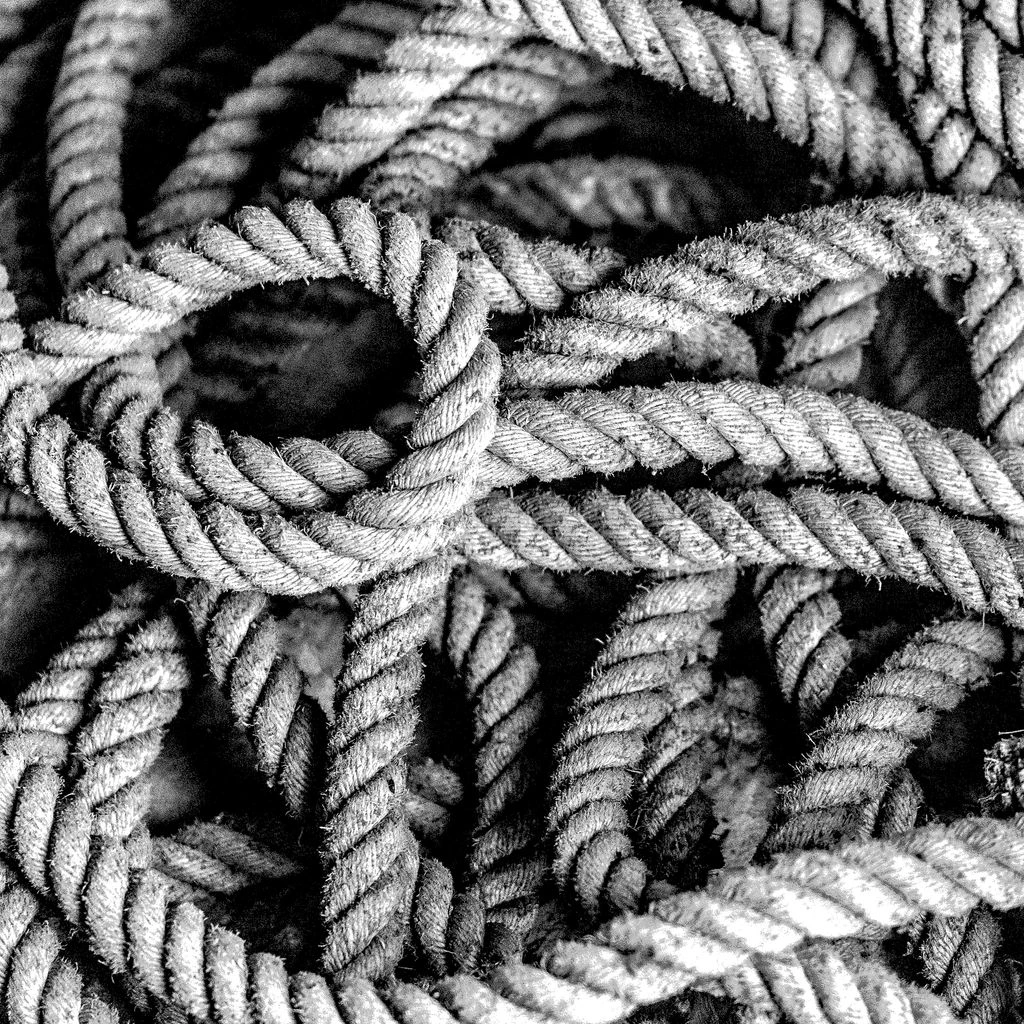 A Cast Bronze-Knot necktie sculpture resting on dark wool.